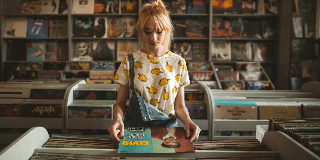 Woman picking out a vintage vinyl at a music store.
