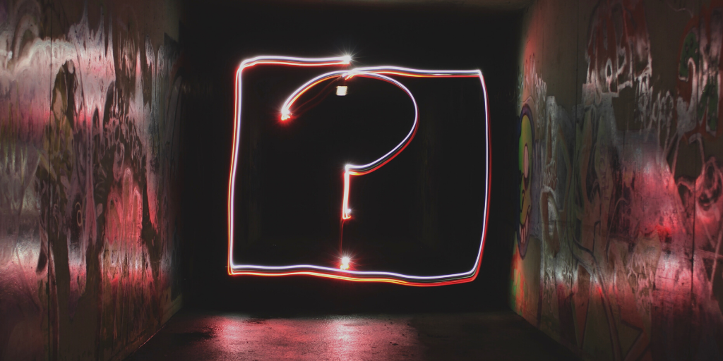 room with neon colored large question mark