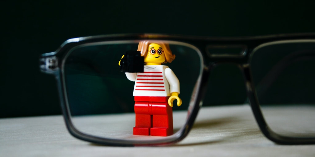 Toy minifigure behind an eyeglasses frame
